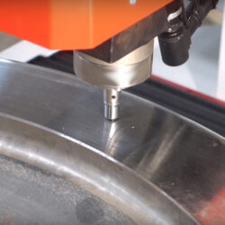 CNC machine precision drilling on metal surface, showcasing advanced manufacturing technology.
