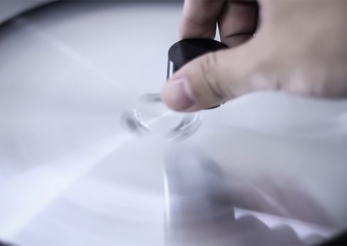 Hand spinning a record on a turntable, emphasizing motion blur and speed in a close-up view.