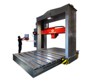 Large industrial CNC machine in operation with technician using a control panel.