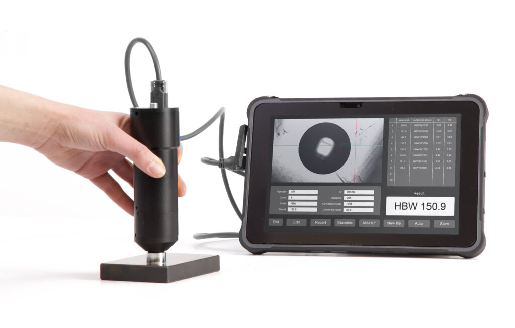 Hand using portable hardness tester with digital display showing HBW 150.9 reading.