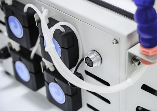 Close-up of tubes and connectors on a laboratory machine for fluid management and control.